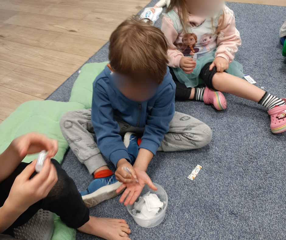 Dziecko podczas warsztatów prozdrowotnych w przedszkolu w Warszawie ćwiczy opatrywanie ran i używanie materiałów z apteczki